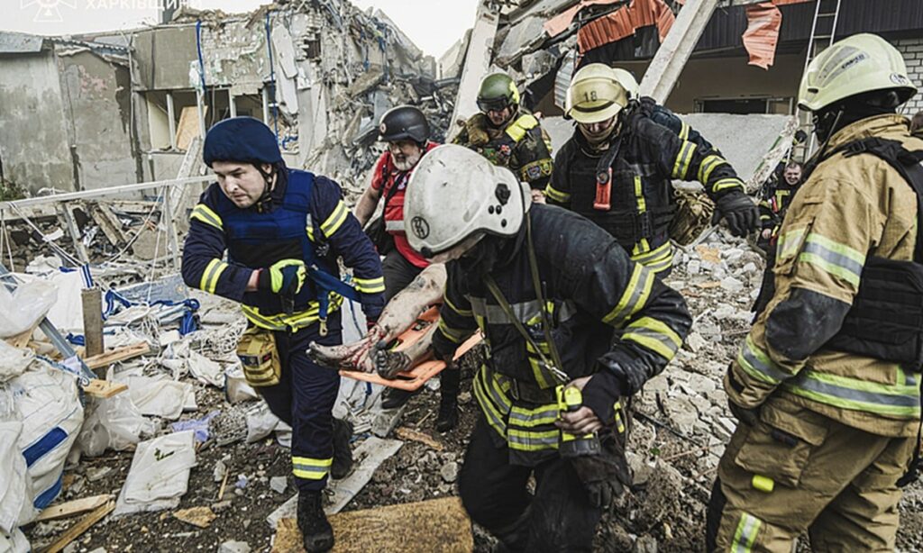 In this photo provided by the Ukrainian Emergency Service, emergency services personnel carry a body of a victim following a Russian rocket attack in Kharkiv, Ukraine, Tuesday, Tuesday, June 10, 2025. (Ukrainian Emergency Service via AP)