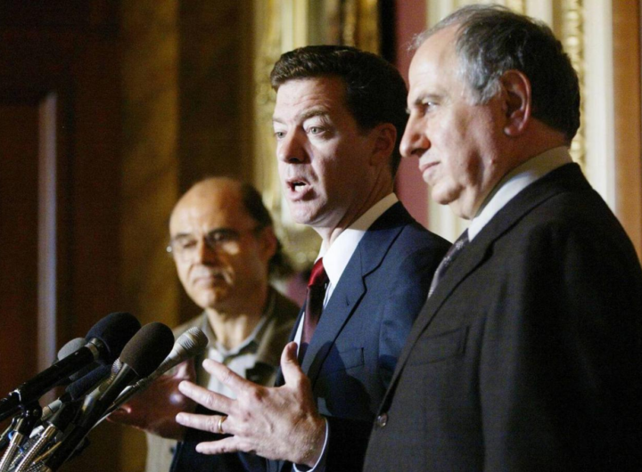 نشست خبری در کنگرهٔ آمریکا، ۲ اکتبر ۲۰۰۲. از راست به چپ، احمد چلبی، سم براون‌بک (نمایندهٔ جمهوری‌خواه آمریکایی)، و کنعان مکیه دربارهٔ آزادی عراق از طریق حملهٔ نظامی و آیندهٔ دموکراتیک پس از صدام سخن می‌گویند. 
عکس از Zuma Press.