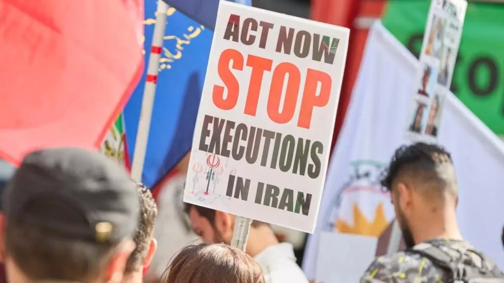 یک معترض پوستری علیه اعدام‌ها در ایران به دست دارد. هامبورگ، آلمان، ۱۴ سپتامبر ۲۰۲۴. عکس از Amnesty International / Georg Wendt / DPA / dpa Picture-Alliance via AFP.