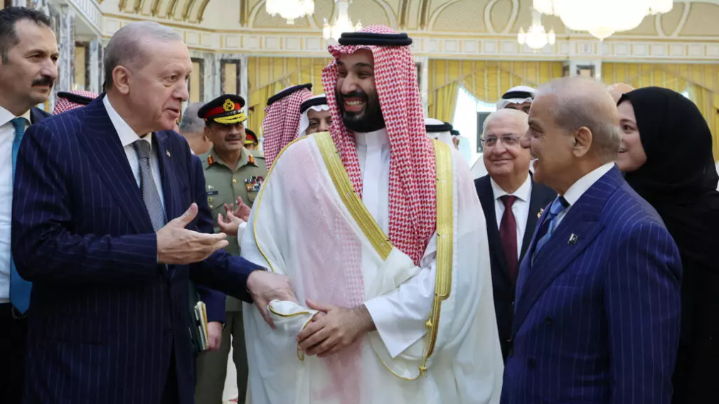 رجب طیب اردوغان، رئیس‌جمهور ترکیه، محمد بن سلمان، ولیعهد عربستان سعودی، و شهباز شریف، نخست‌وزیر پاکستان، پس از امضای توافق‌نامهٔ دفاعی مشترک در مکه، عربستان سعودی، ۷ اوت ۲۰۲۶ (۱۶ مرداد ۱۴۰۵). 
عکس از via REUTERS - Murat Cetinmuhurdar/PPO